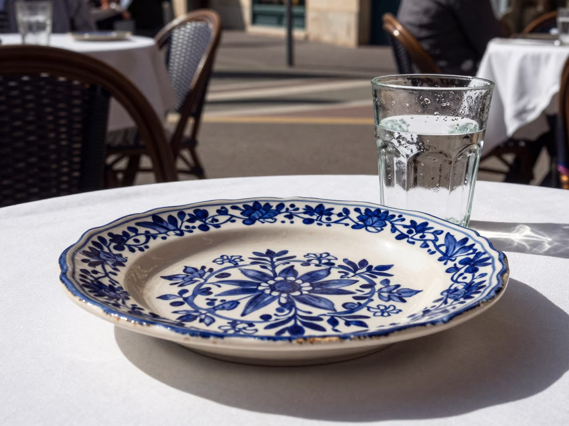 Sunlit Cafe Terrace in Nice France with Vintage Majolica Plate and Condensation in in Nice, France