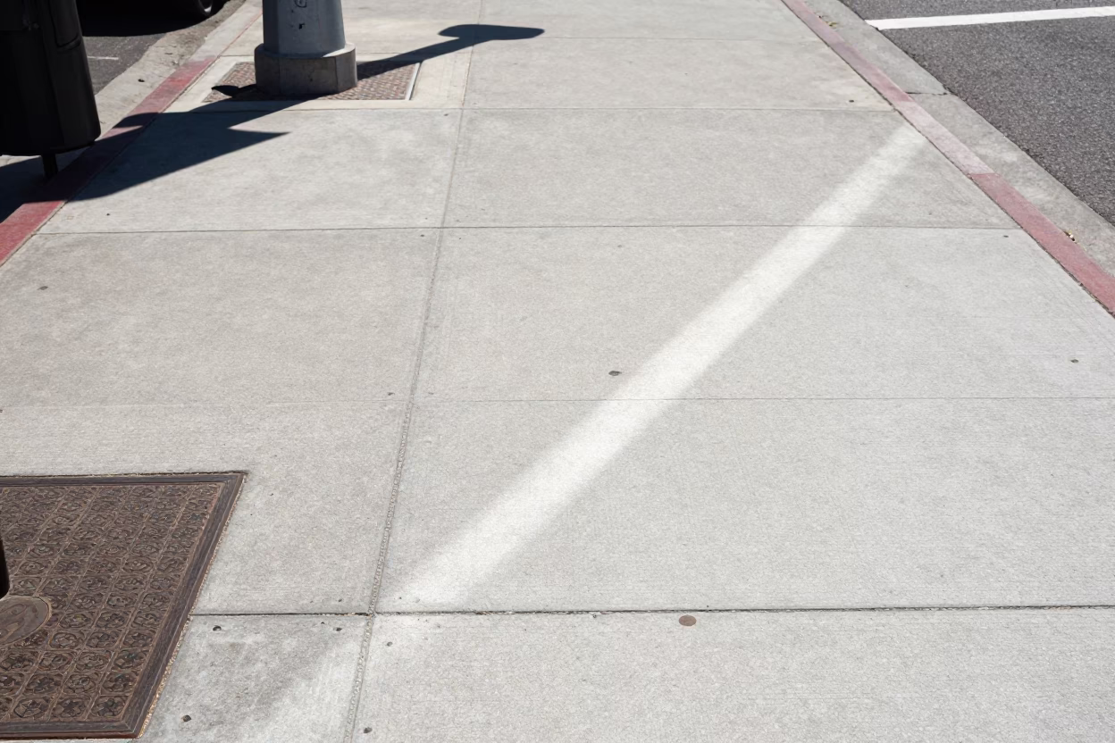 Sunlit Concrete Sidewalk and Street Sign in Midday Los Angeles California in in Los Angeles, California, United States