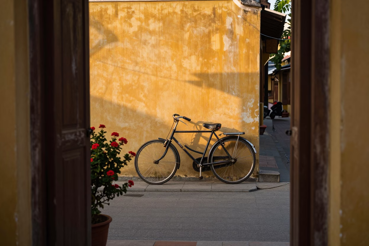 Sunlit Hoi An Street Scene with Bicycle and Geraniums in Vietnam in in Hoi An, Vietnam