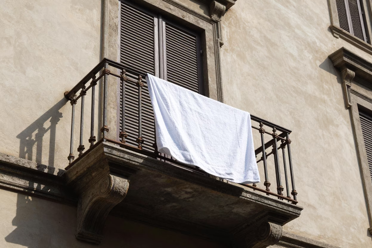 Sunlit Milanese Balcony with Towel Edge and Threadbare Cushion Detail in in Milan, Italy