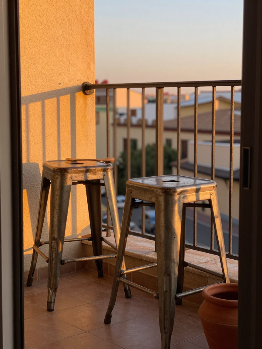 Sunset light on Madrid balcony with metal stools and olive wood spoon in in Madrid, Spain