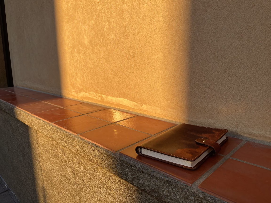Sunset light stripe across ceramic tile in Barcelona street scene with notebook and decanter in in Barcelona, Spain