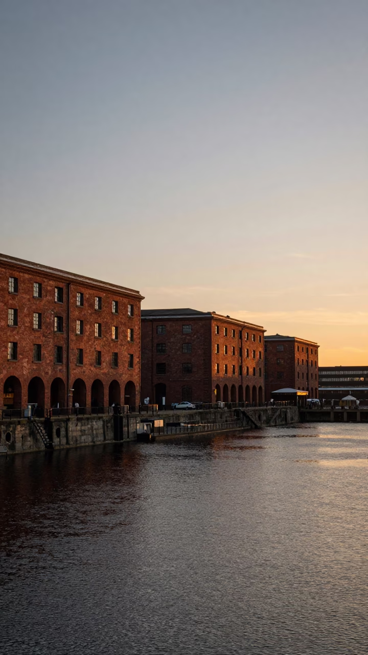Sunset over Liverpool Albert Dock with red brick warehouses and moored boats in in Liverpool, United Kingdom