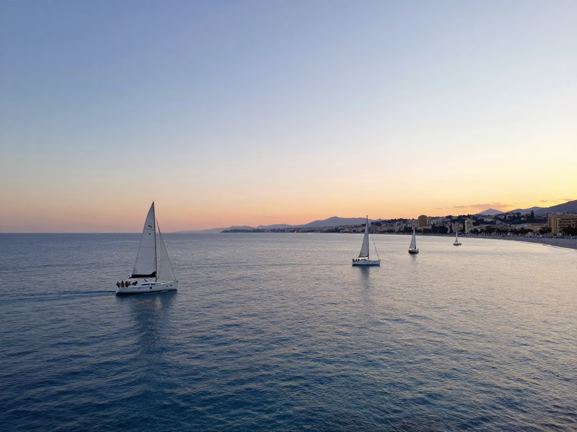 Sunset over Nice France Bay of Angels with sailboats and historic architecture in in Nice, France