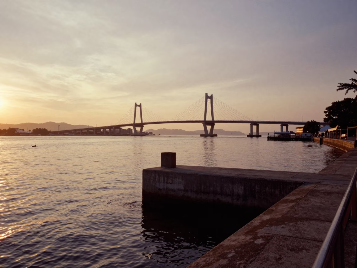 Sunset over Penang Bridge pier cutwater splitting brown river water in George Town Malaysia in in George Town, Malaysia