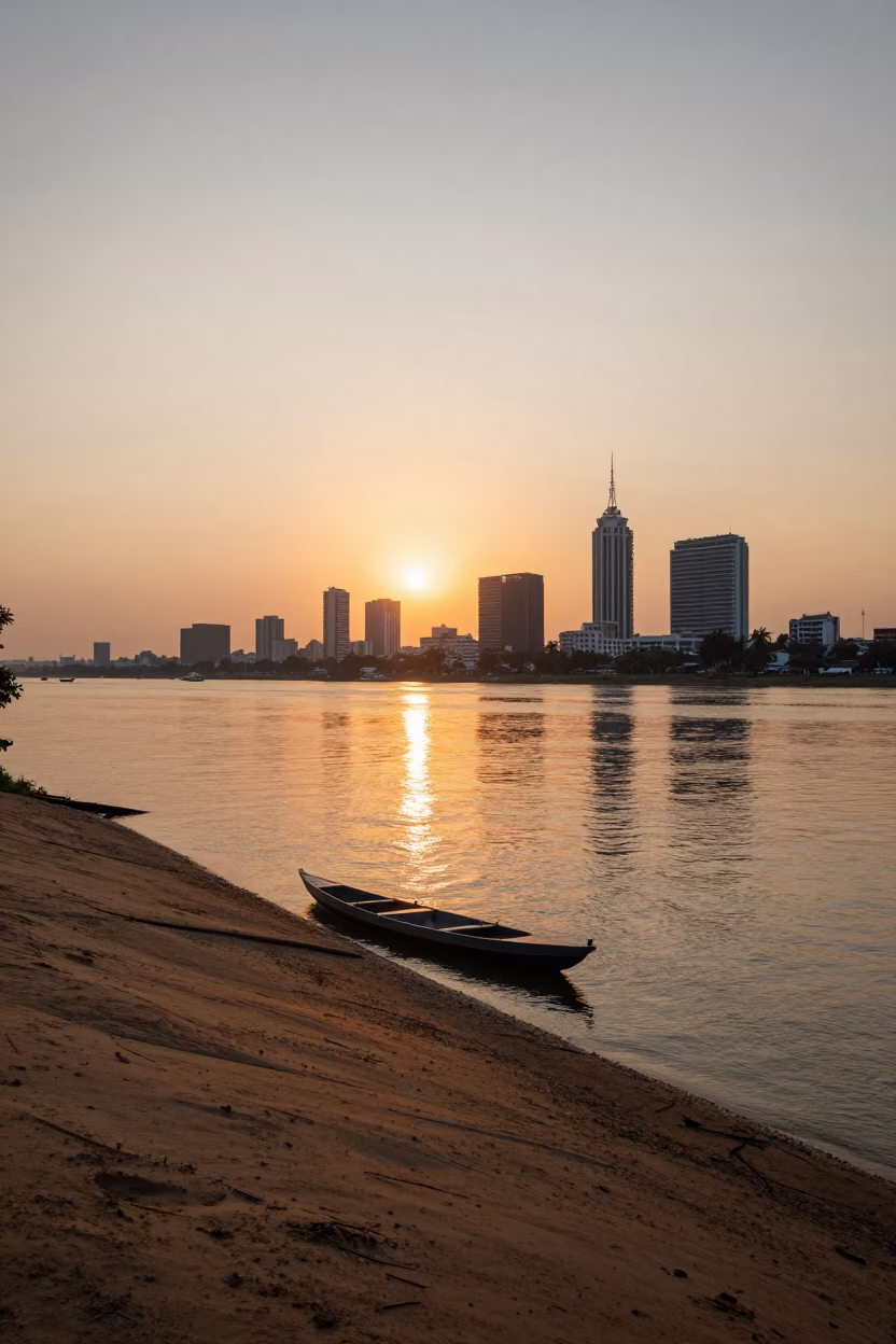 Sunset Over Phnom Penh Riverfront With Canoe and Urban Skyline in in Phnom Penh, Cambodia