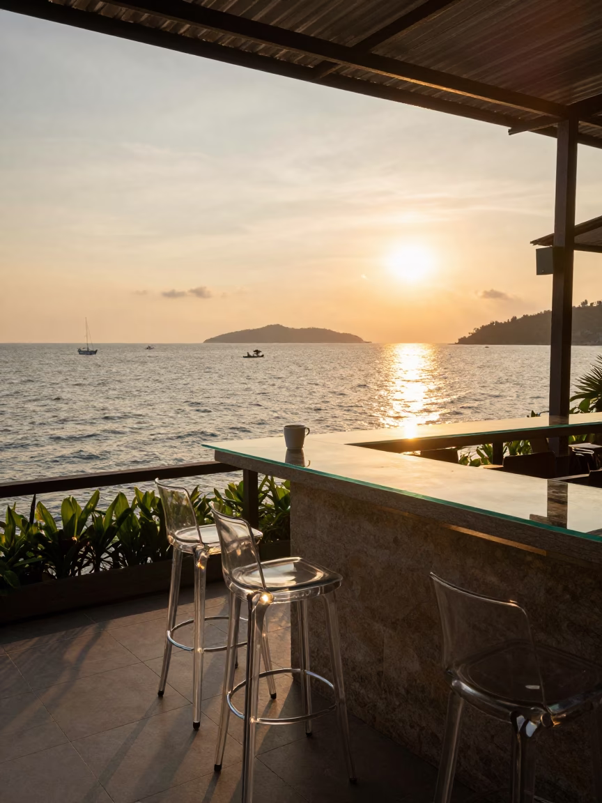 Sunset View from Phuket Restaurant Terrace with Glass Stools and Ocean Horizon in in Phuket, Thailand