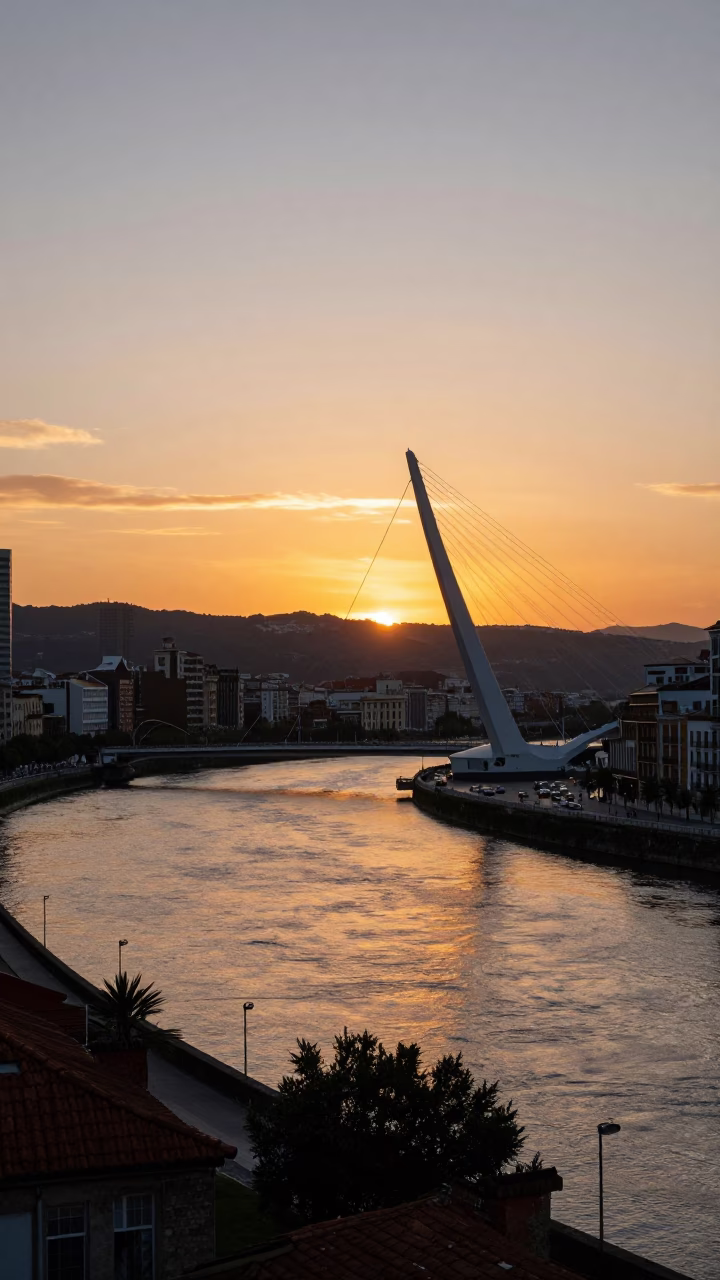 Sunset view of Bilbao's Zubizuri Bridge and Nervion River with historic architecture in in Bilbao, Spain