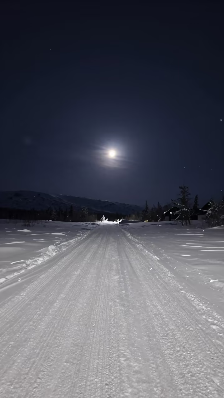 Supermoon Over Snowy Lapland Alpine Pass in beneath a hard winter sky over snowfields in Lapland