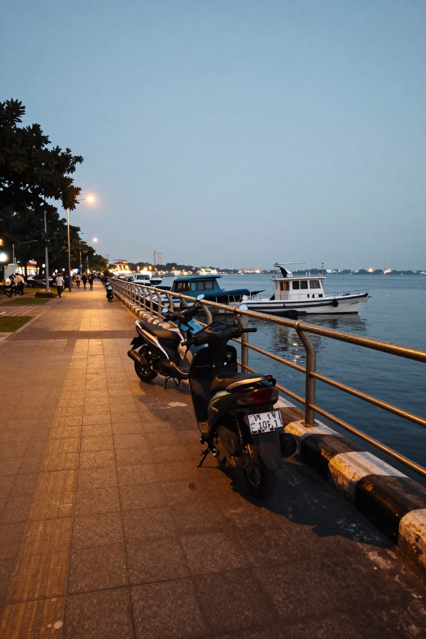 Surabaya Indonesia early evening harbor promenade street scene with parked scooter and local activity in in Surabaya, Indonesia