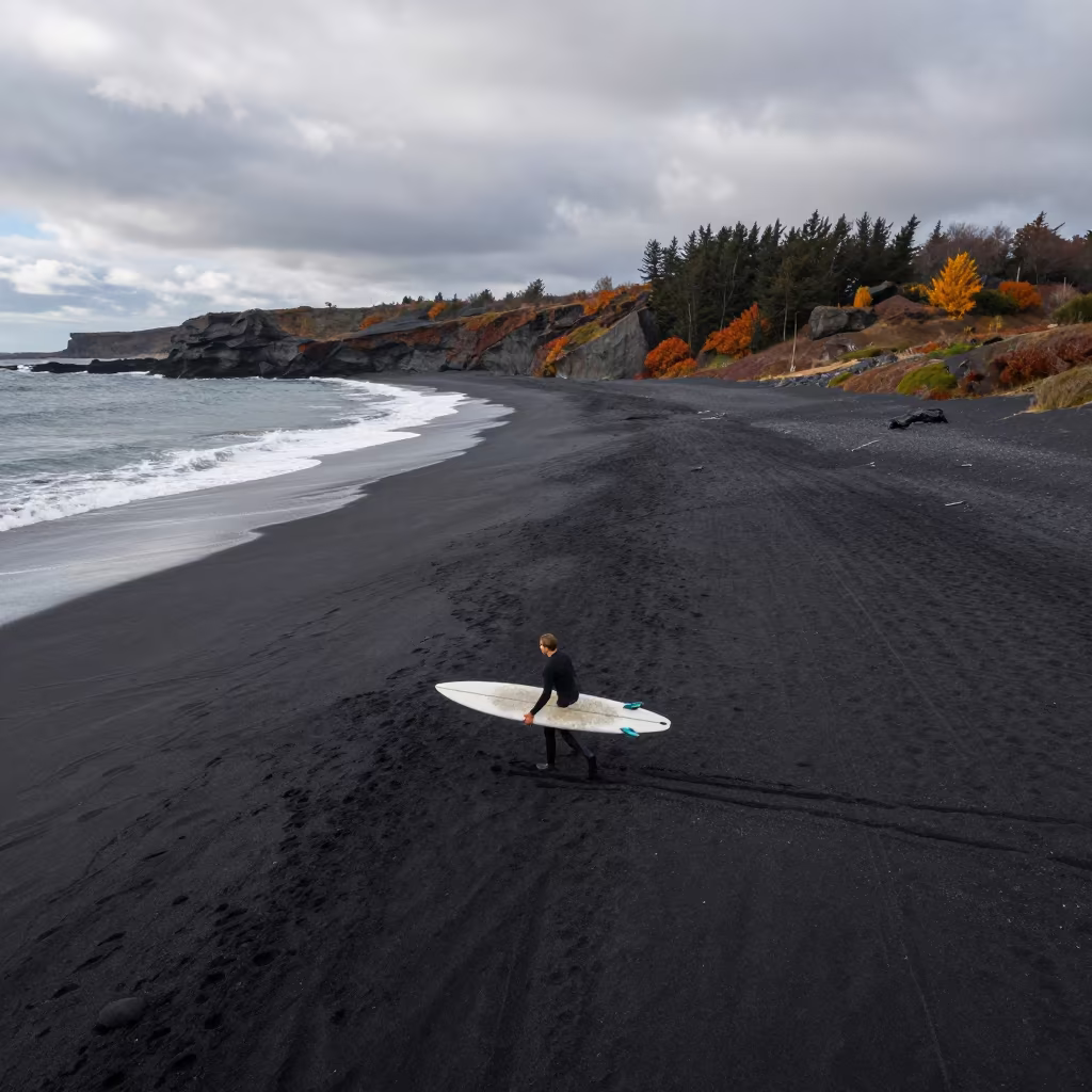 Surfer Carries Longboard Across Volcanic Sand in along a wave-cut shoreline in Tyrol