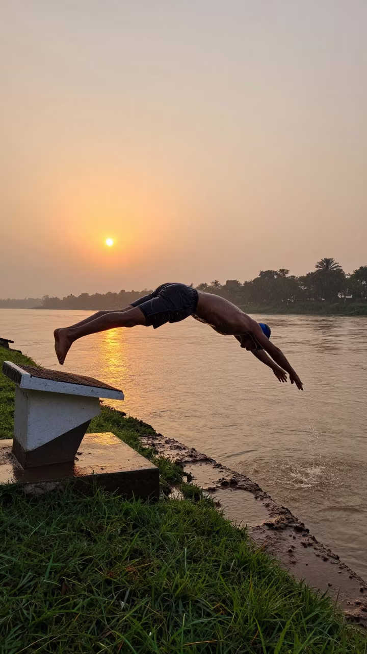 Swimmer Dives Into River at Sunset During Rain in by a riverbank near Mira-Bhayandar