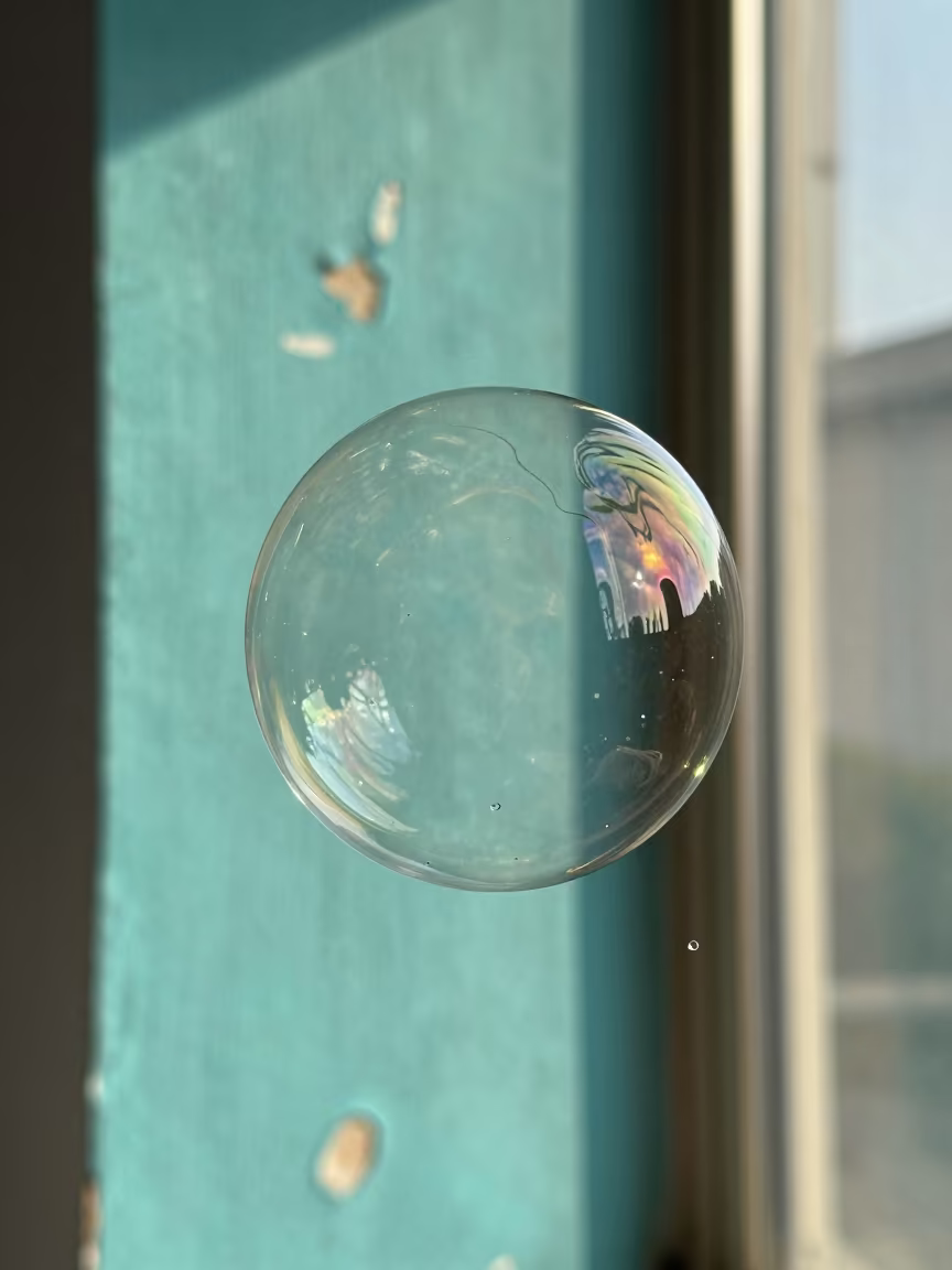 Swirling Soap Bubble Colors Against Turquoise Wall in against weathered turquoise paint in Barbacena