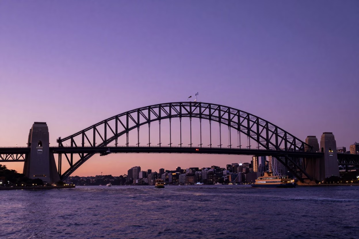Sydney Harbour Bridge at Sunset with Ferry and Urban Skyline Reflections in in Sydney, New South Wales, Australia