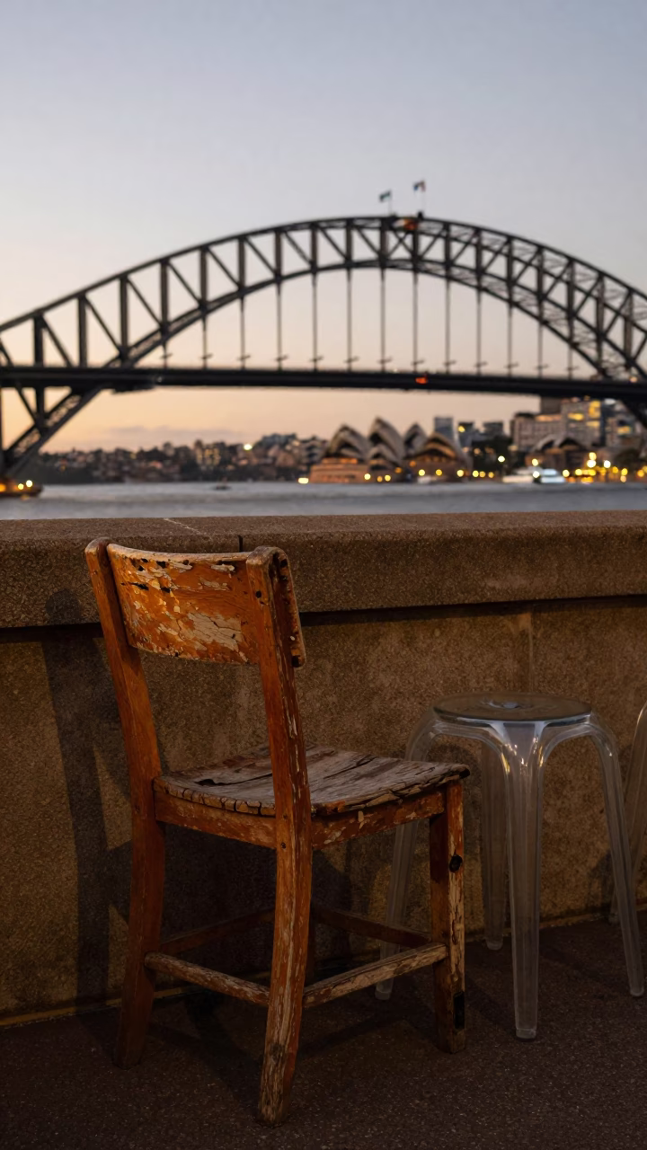 Sydney Harbour Bridge Evening Light with Worn Wooden Chair and Glass Stool on Balcony in in Sydney, New South Wales, Australia