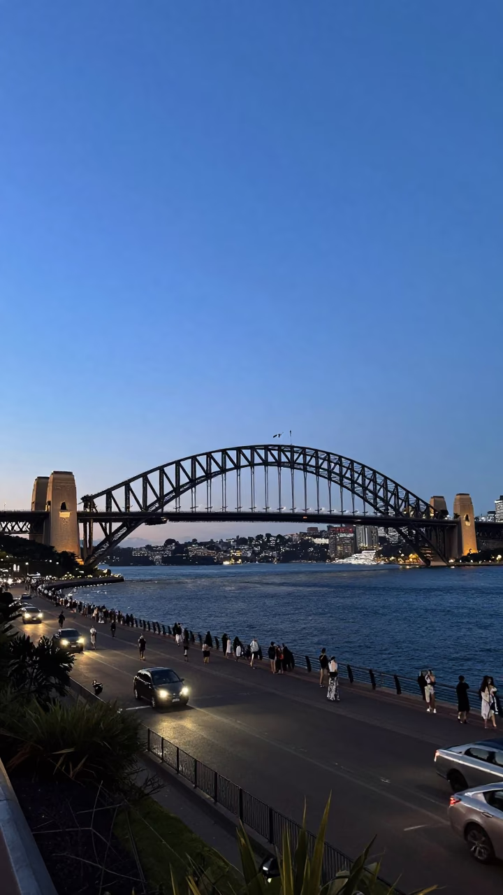 Sydney Harbour Bridge twilight view from a bustling outdoor cafe terrace in in Sydney, New South Wales, Australia