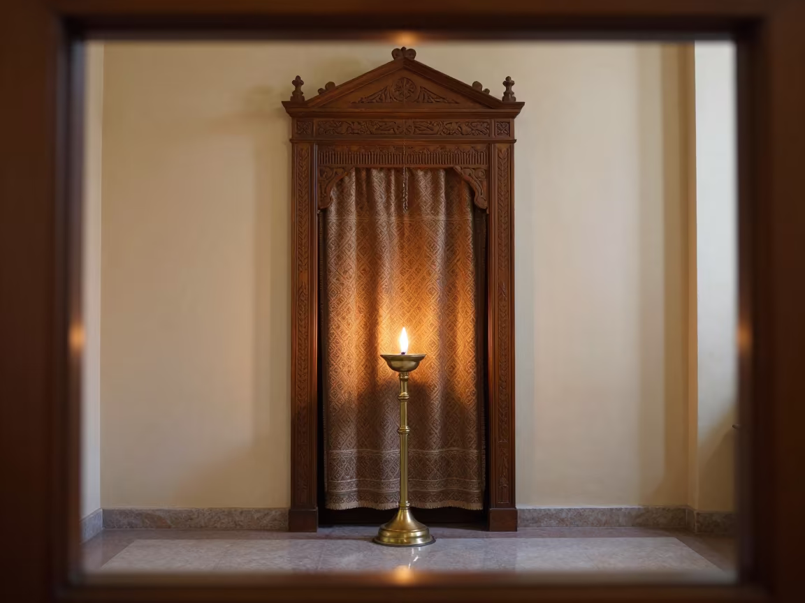 Synagogue Eternal Flame Warm Glow on Ark Curtain in beside a carved Torah ark in Bologna