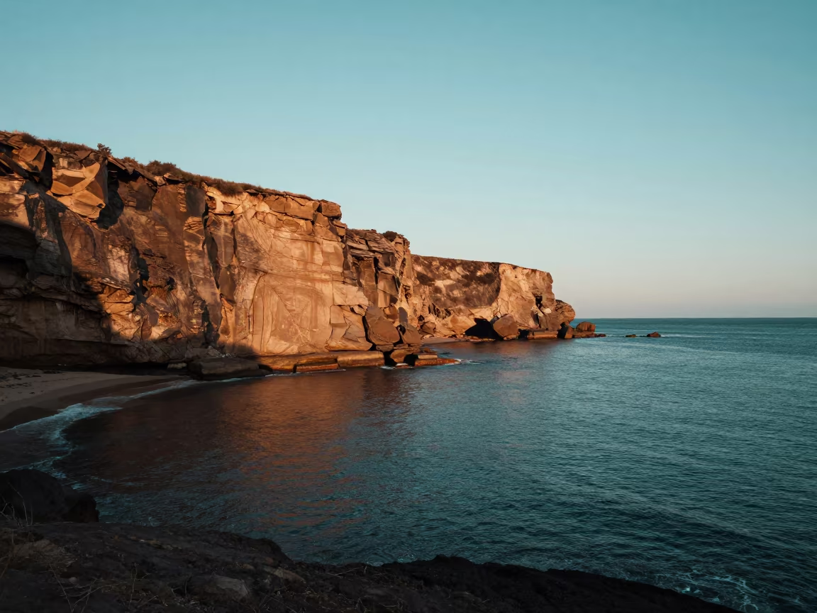 Teal Ocean Meets Ochre Cliff at Tanzanian Dawn in along a wave-cut shoreline in Tanzania