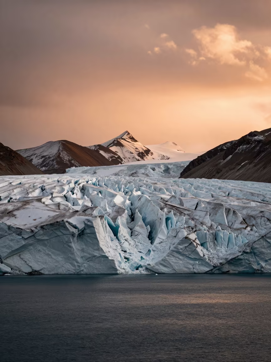 Tibetan Glacier Calving into Fjord at Dusk in from a ridge above layered foothills in Tibet