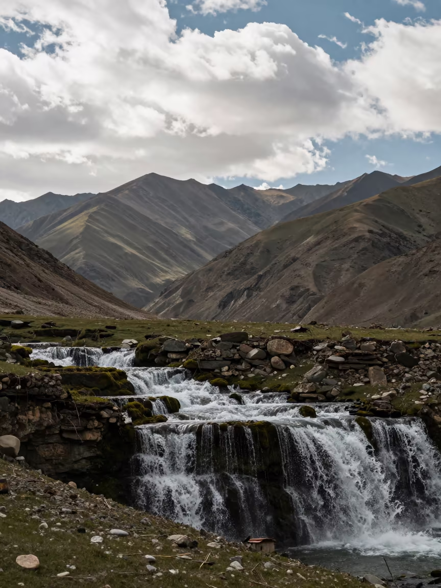Tiered Waterfall on Mossy Terraces Near Leh in from a ridge above layered foothills near Leh