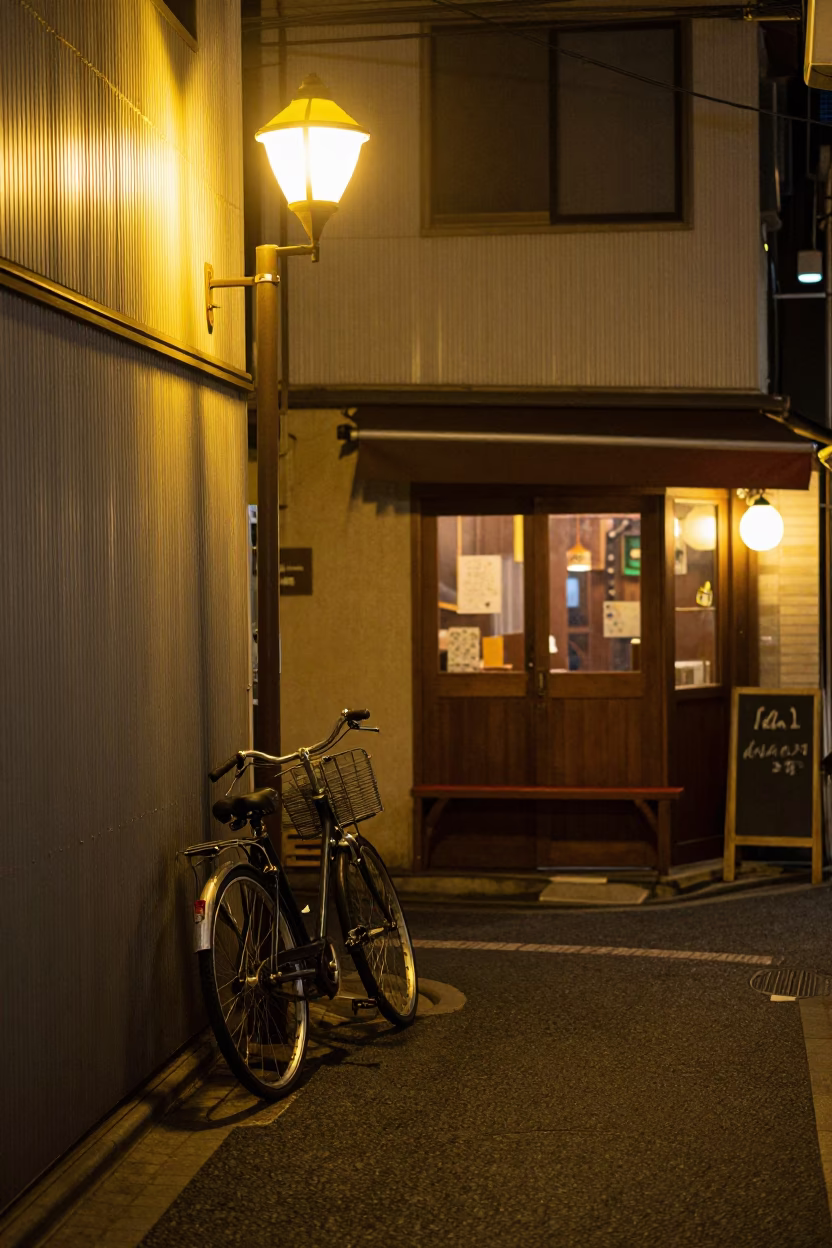 Tokyo Night Street Scene with Bicycle Leaning Against Cafe and Brushed Steel Cup Rim in in Tokyo, Japan