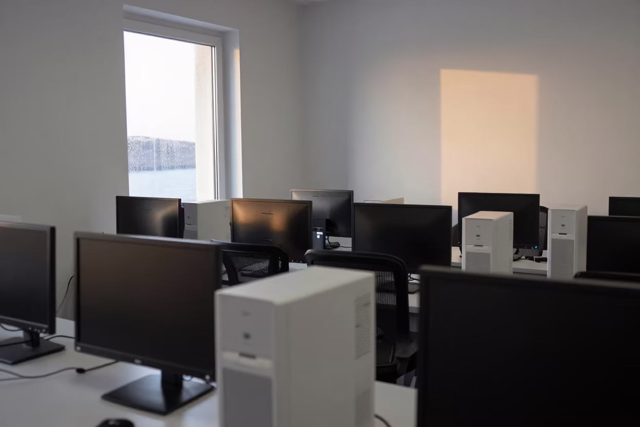 Tower Fan Stands Near Dark Monitors in in a computer lab before lessons near Santorini