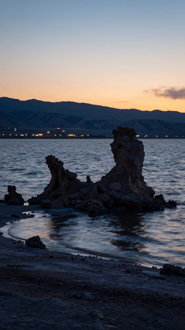Tufa Towers Silhouetted Against Glowing Lake Lights in from a ridge above layered foothills in Utah