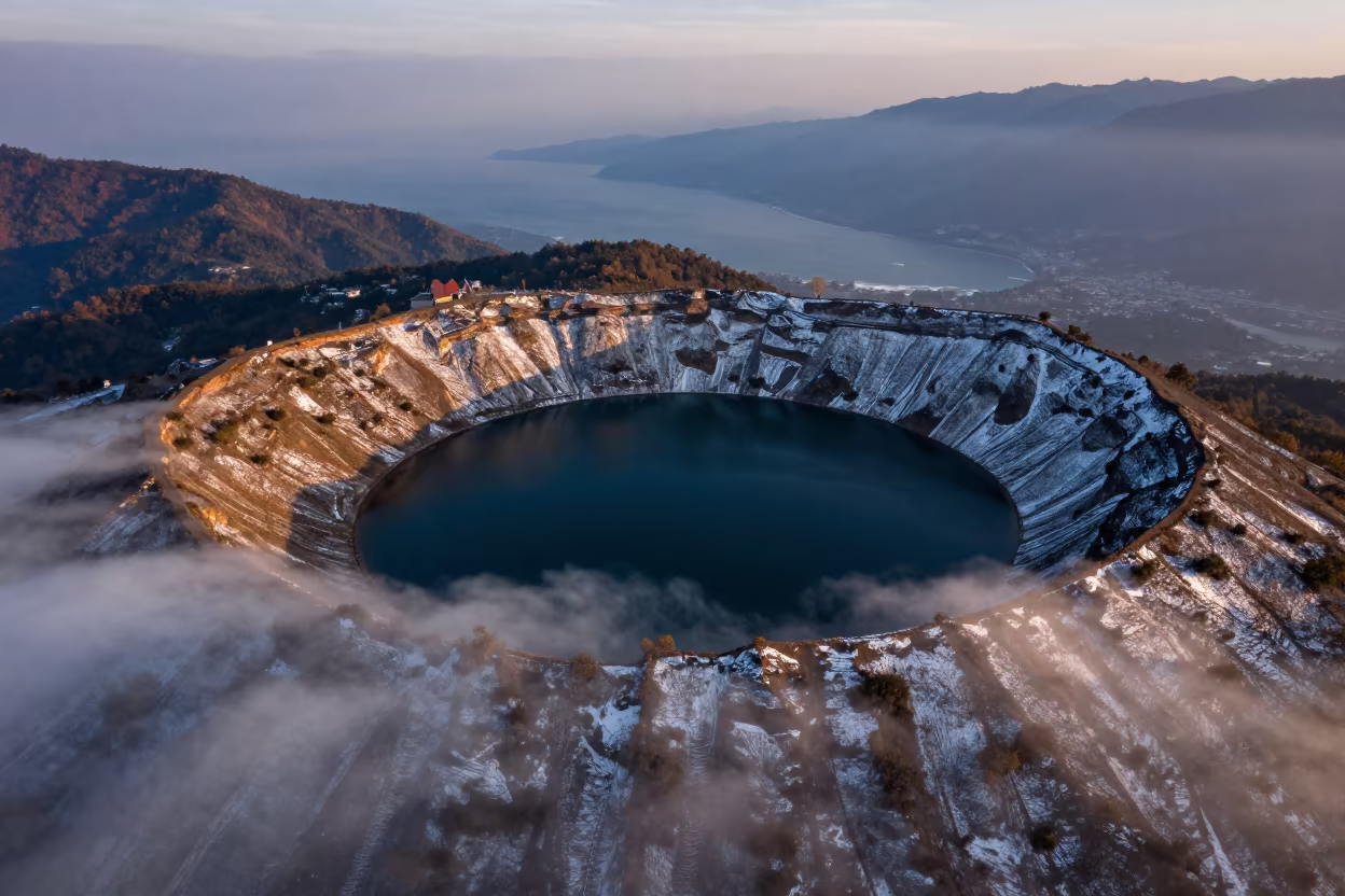 Twilight aerial view of snow crater lake near Pokhara in far above surf-scalloped coastline near Pokhara
