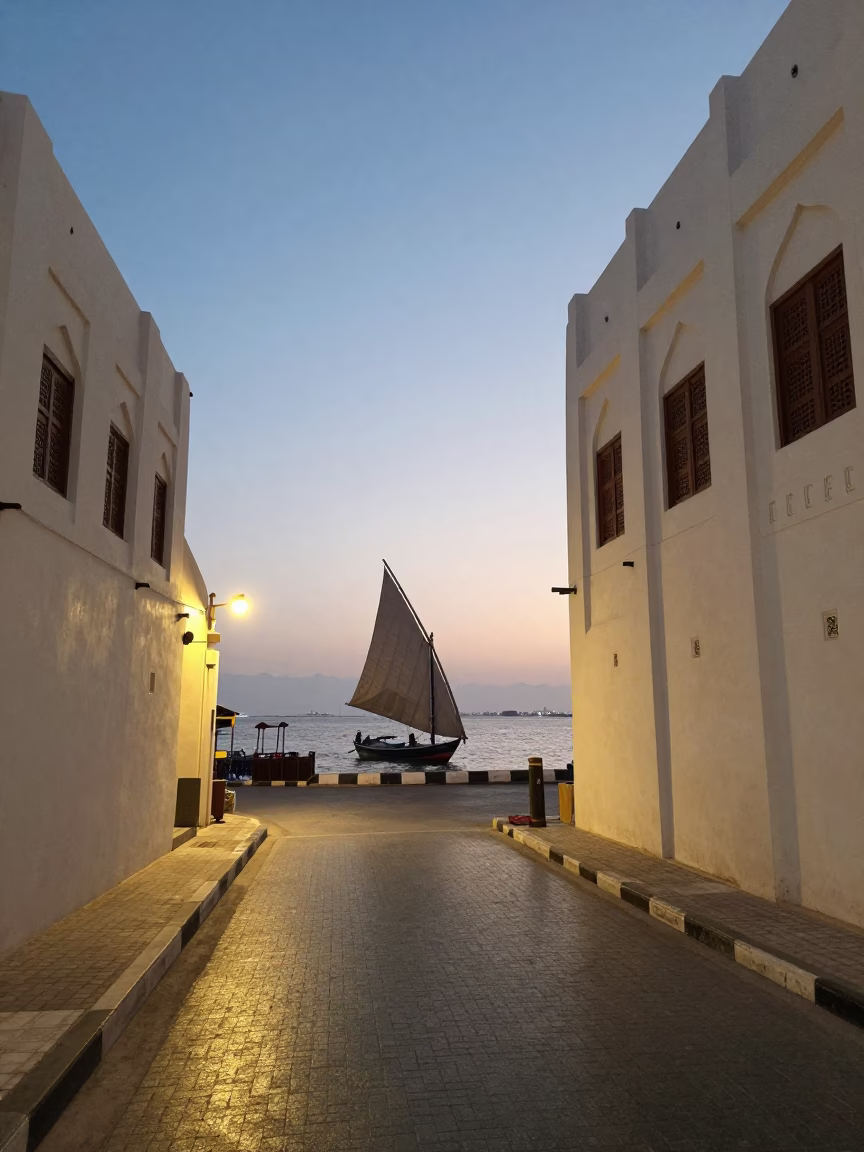 Twilight Street Scene in Muscat Oman with Traditional Dhow Sailing at Sunset in in Muscat, Oman