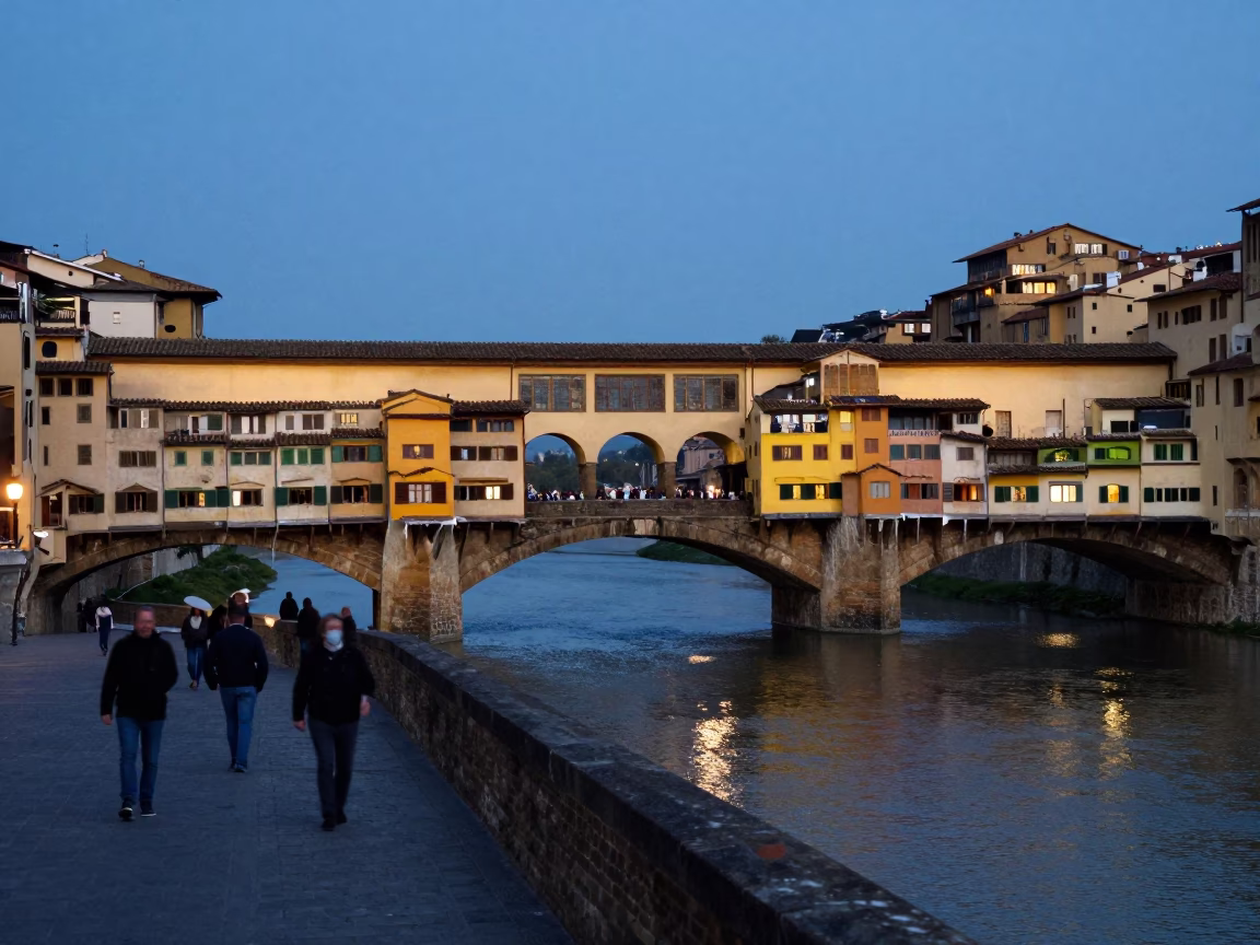 Twilight view of Florence Ponte Vecchio bridge with pedestrians and historic stone architecture in in Florence, Italy