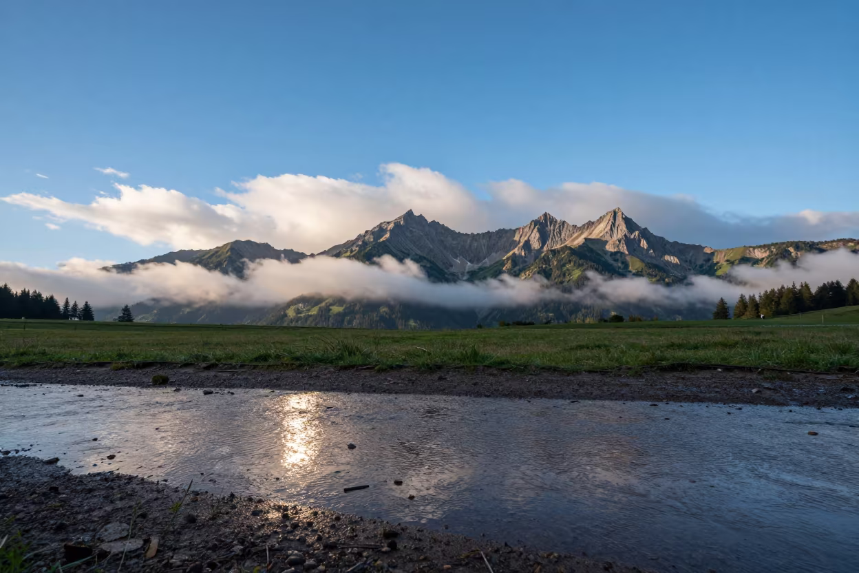 Tyrolean Ridge Above Clouds Late Afternoon in across a floodplain after rain in Tyrol