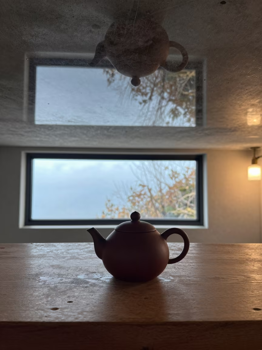 Upside-Down Cedar Teapot Reflected in Water Ceiling in on a wooden workbench near Fukuoka