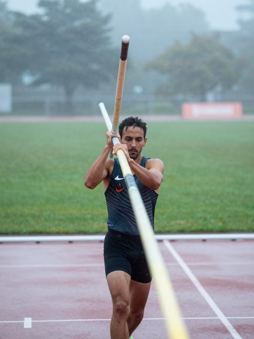 Vaulter Carries Poles Through Predawn Fog in near open fields near Carlos Manuel de Céspedes