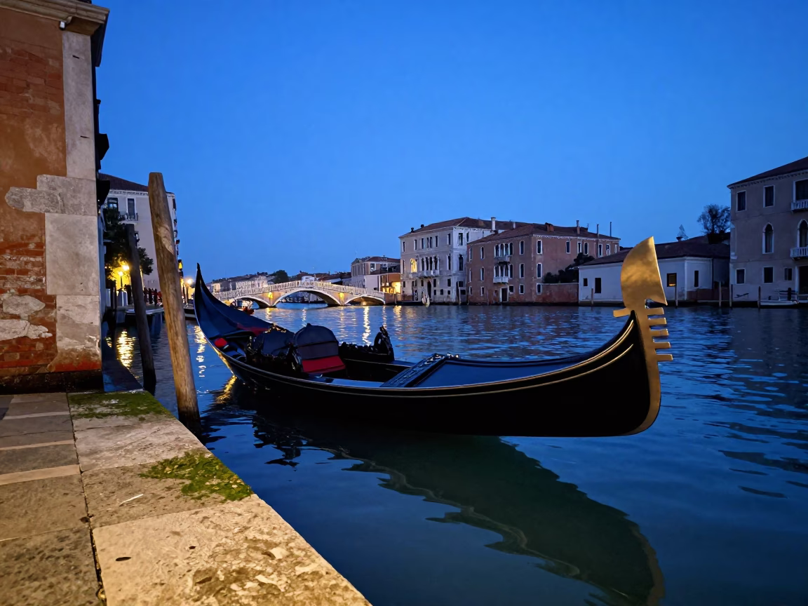 Venice blue hour canal reflection with parked gondola and distant bridge in in Venice, Italy
