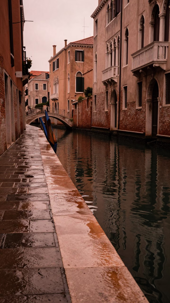 Venice Italy copper-toned dusk canal scene with wet flagstones and traditional gondola in in Venice, Italy