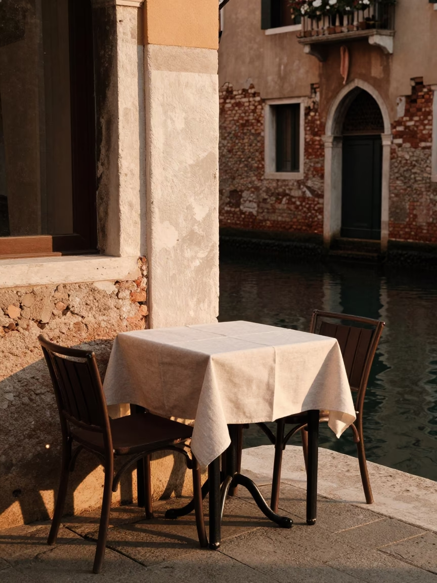 Venice Italy Golden Hour Canal Scene with Local Cafe Table and Linen Napkin in in Venice, Italy