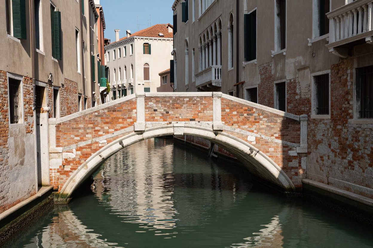 Venice Italy Midday Sunlight on Historic Brick Canal Bridge and Waterway in in Venice, Italy