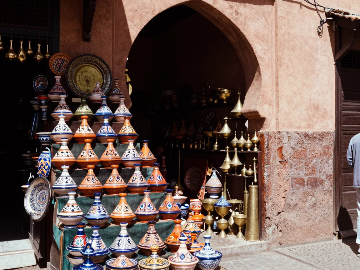 Vibrant Marrakech Souk Stall Displaying Ceramic Tagines and Brass Lanterns Under Noon Sunlight in in Marrakech, Morocco