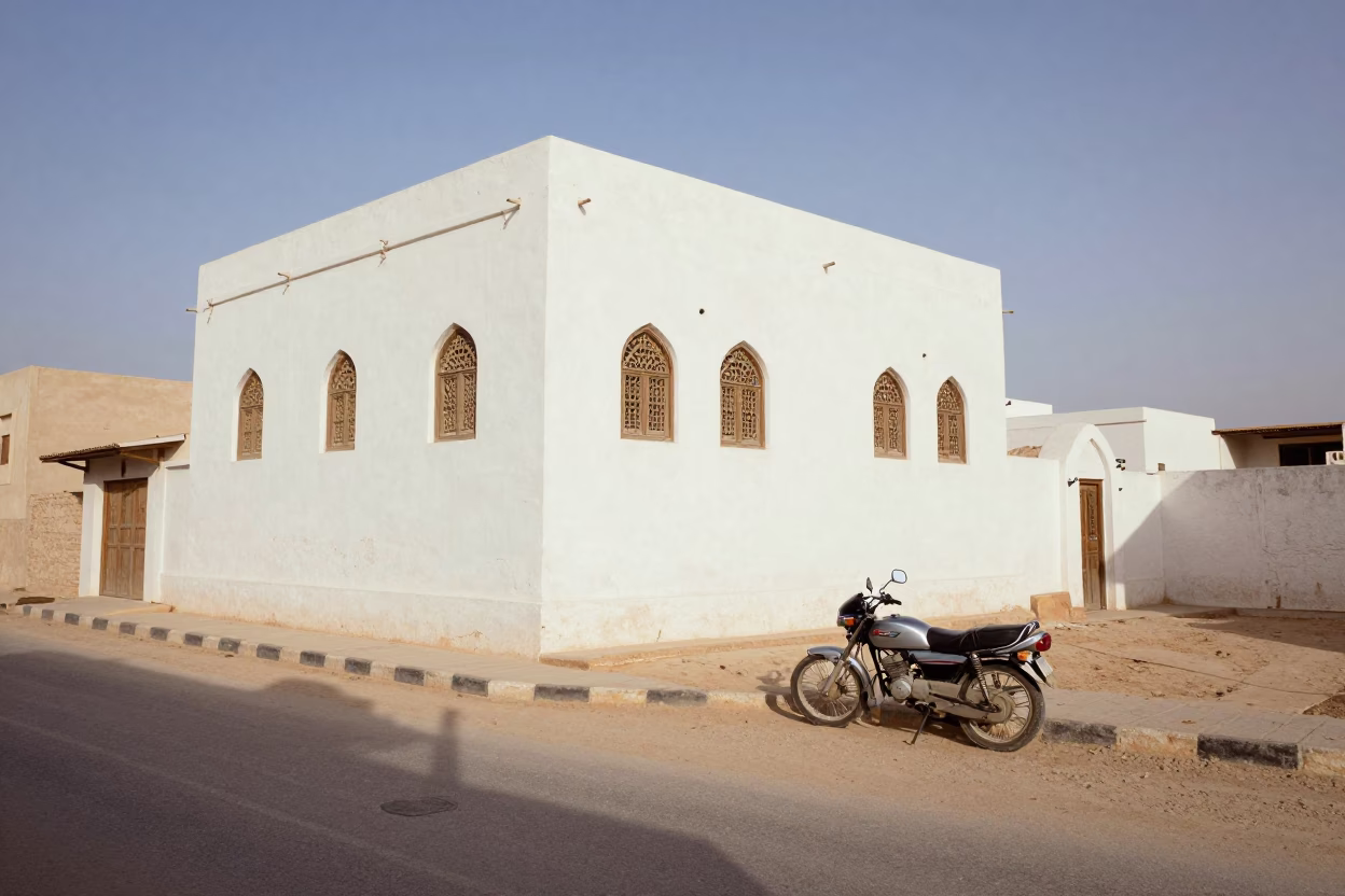 Vintage 1980s Muscat Street Scene with White Building and Coastal Highway Motorcycle in in Muscat, Oman