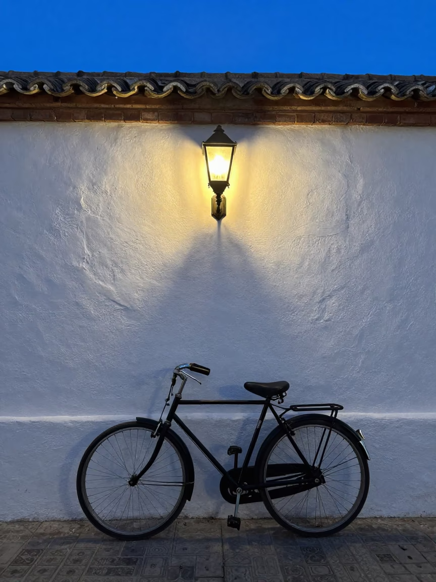 Vintage Bicycle Leaning Against White Stucco Wall in Granada Spain During Indigo Twilight in in Granada, Spain