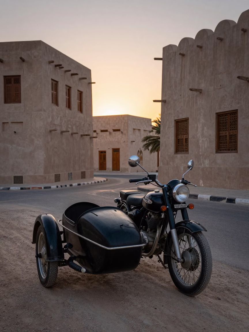Vintage motorcycle with sidecar parked near coral stone buildings at dawn in Muscat Oman in in Muscat, Oman