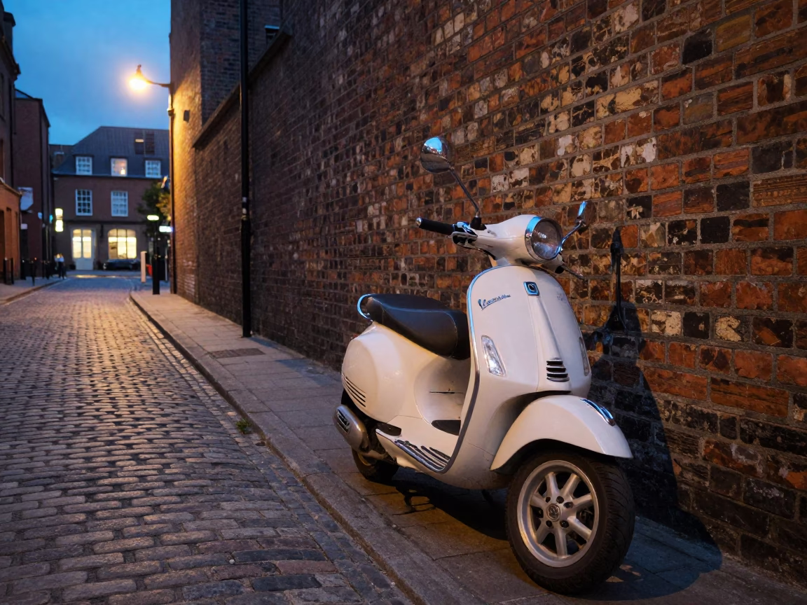 Vintage Vespa Parked on Cobblestone Lane in Liverpool at Dusk in in Liverpool, United Kingdom