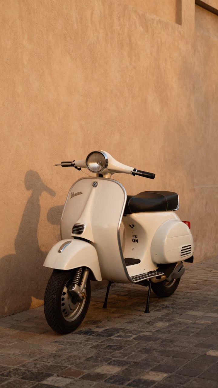 Vintage Vespa parked on cobblestone lane in Muscat Oman honeyed evening light in in Muscat, Oman
