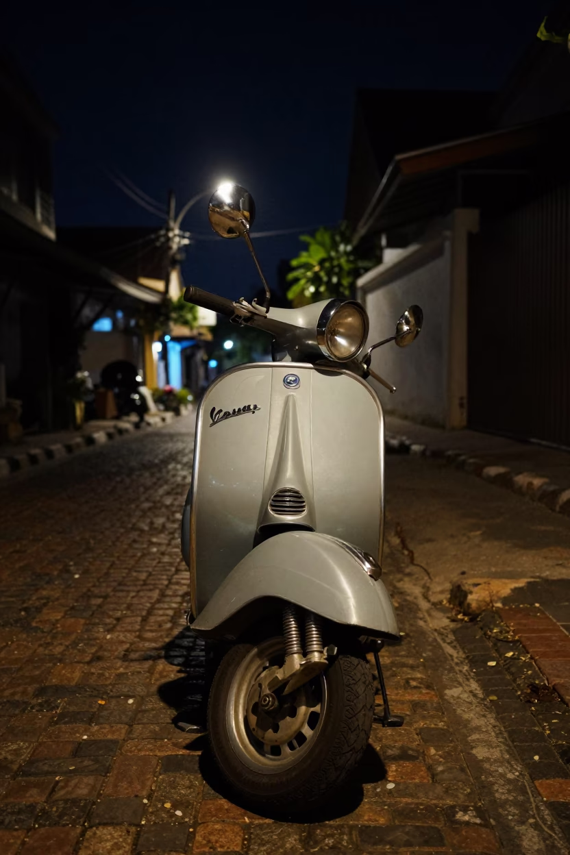 Vintage Vespa parked on cobblestone lane in Phuket Thailand deep night street photography in in Phuket, Thailand