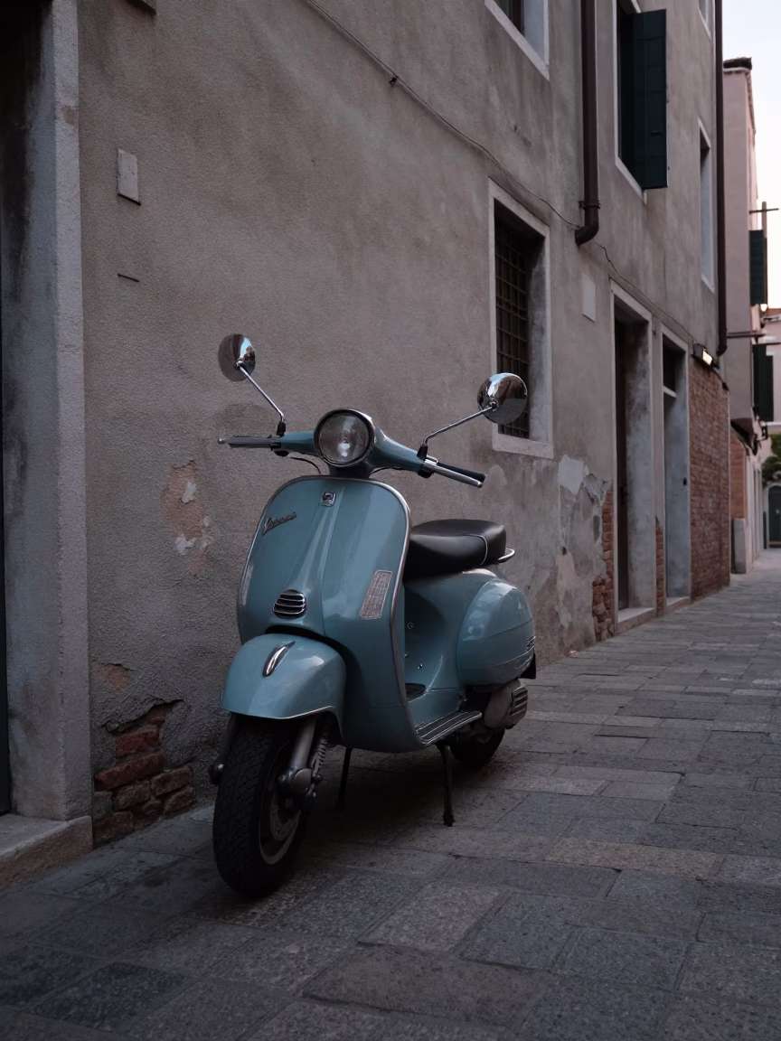 Vintage Vespa Parked on Cobblestone Lane in Venice Italy Before Sunrise in in Venice, Italy