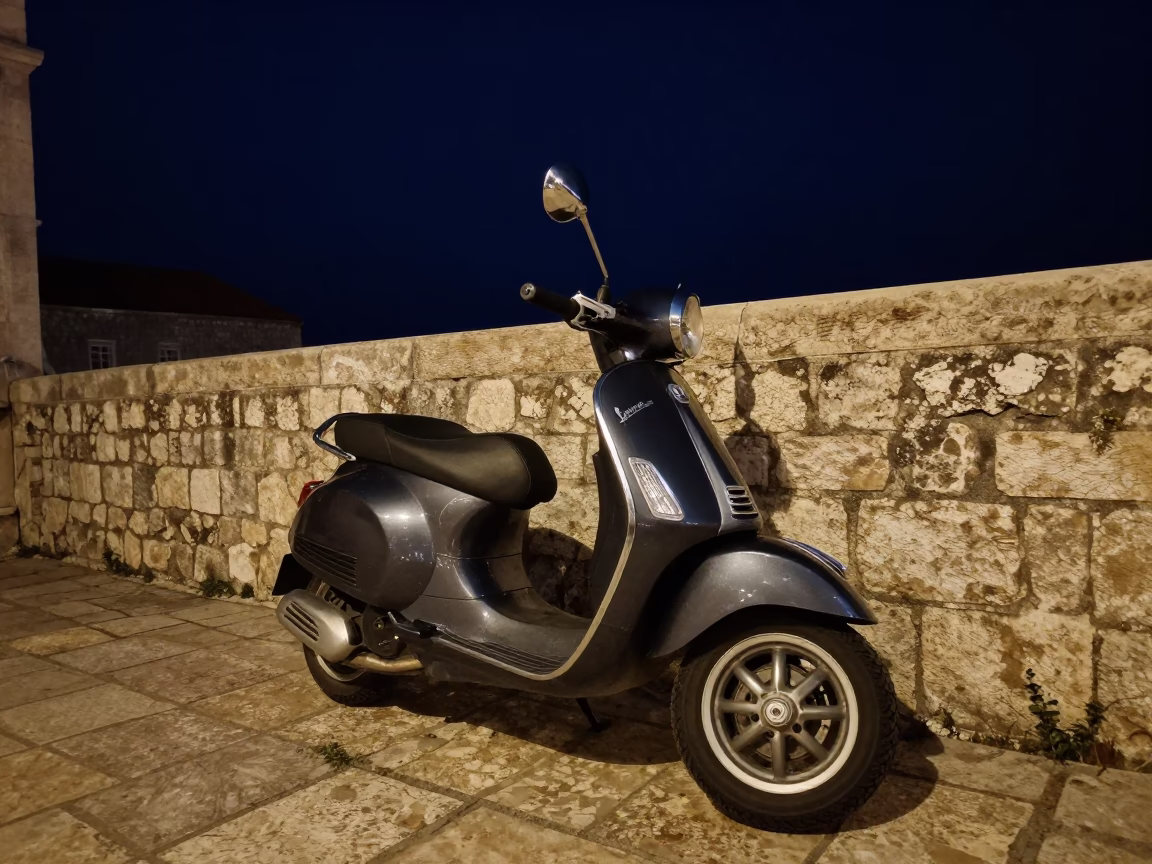 Vintage Vespa parked on Dubrovnik cobblestones under deep night sky in Croatia in in Dubrovnik, Croatia