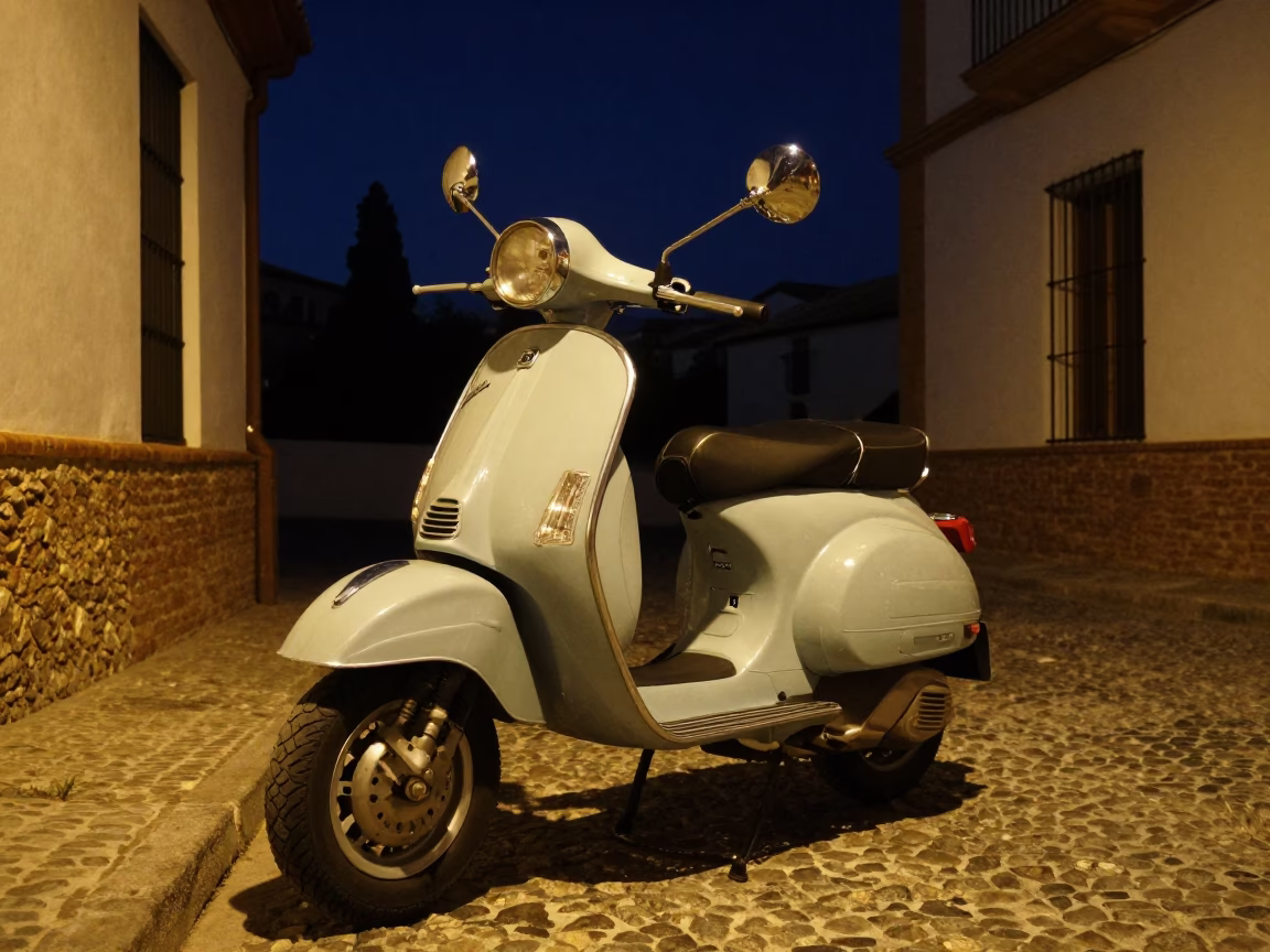 Vintage Vespa parked on Granada cobblestone lane under deep night sky in in Granada, Spain