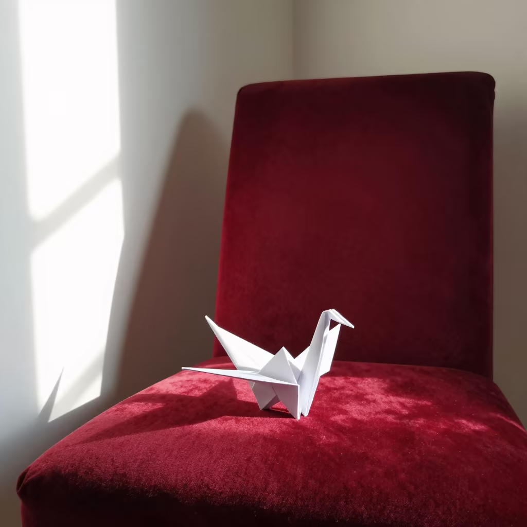 White Paper Crane on Red Velvet Chair in Morning Light in on a velvet chair near Maputo
