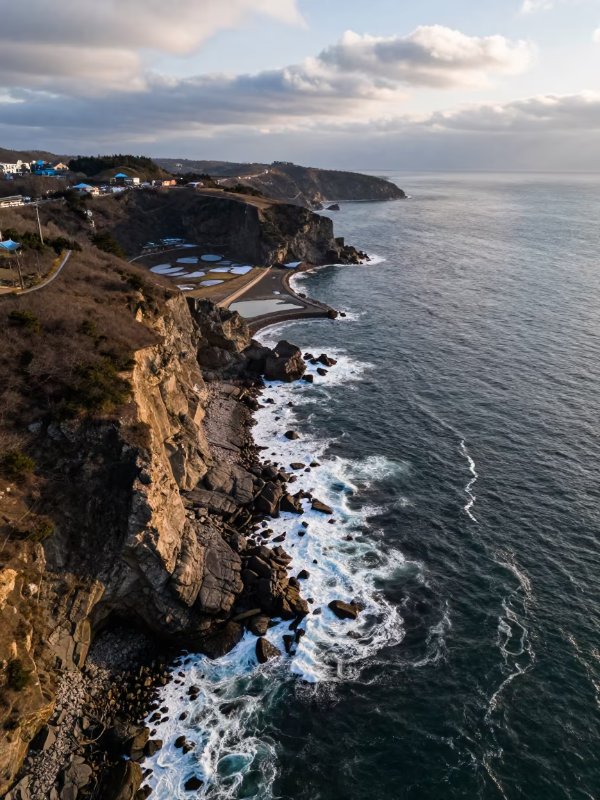 Winter Cliffs Bitten by White Surf Aerial View in high over salt ponds and causeways near Fukuoka