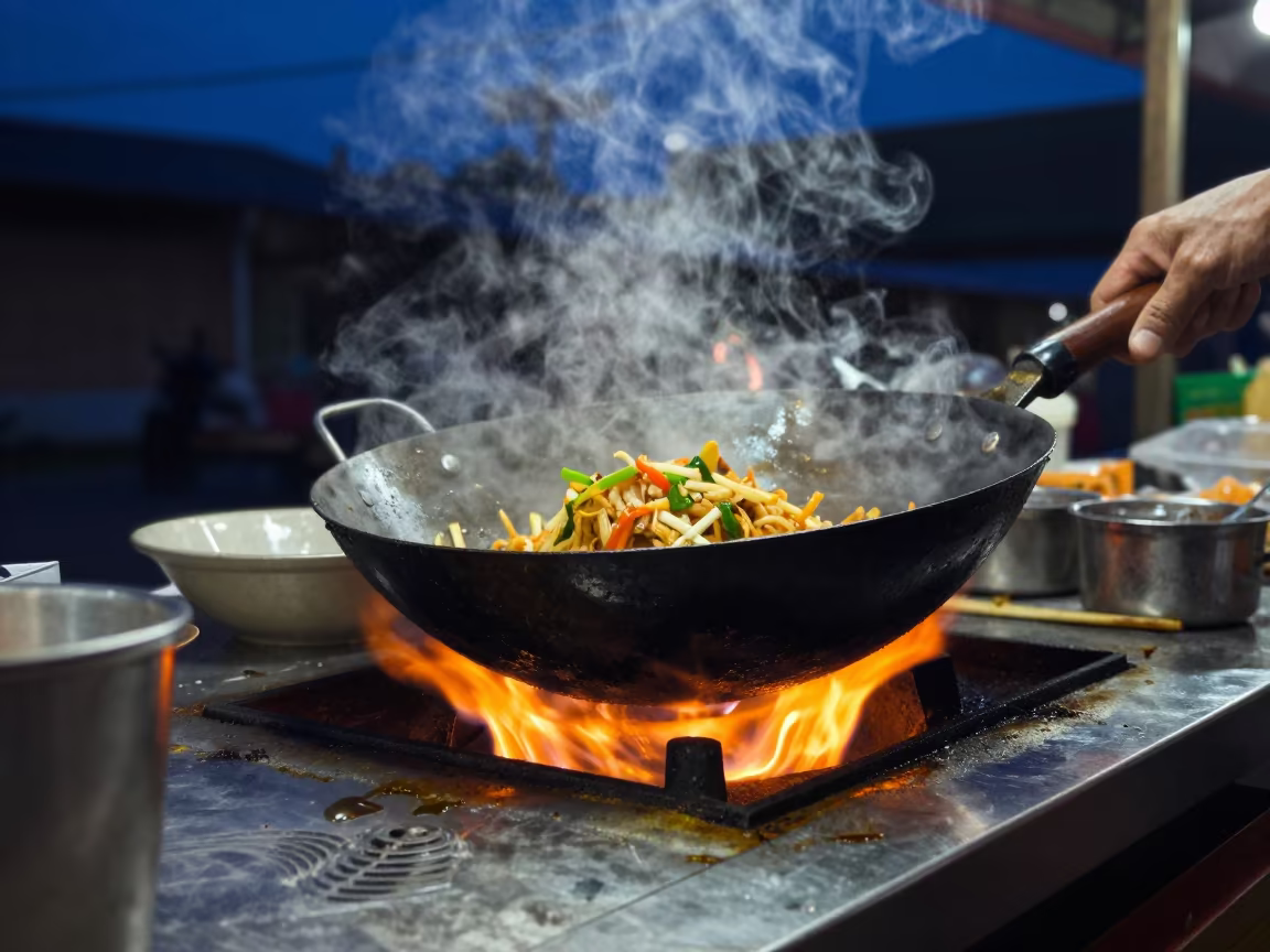Wok Tossing Pad Thai Over Blue Hour Flame in at a fish market counter near Phuket